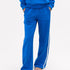 Close-up of blue track pants with white side stripe and matching sweatshirt.