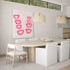 Modern dining room with a round wooden table, white chairs, and abstract pink artwork on the wall by Kerri Rosenthal.
