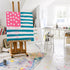Kerri Rosenthal's Sunshine Saltwater Forever Flag original painting displayed on a wooden easel in the Kerri Rosenthal's bright, paint-splattered studio