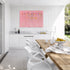 Kerri Rosenthal pink wildflower canvas art above white kitchen counter in coastal outdoor dining space
