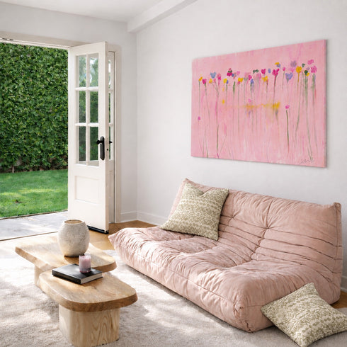 Kerri Rosenthal pink flower painting above blush velvet sofa in living room with garden view