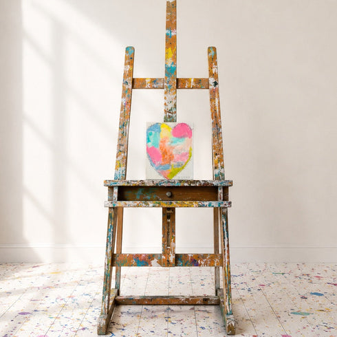 Kerri Rosenthal colorful abstract heart painting on canvas hanging on white wall on easel in art studio