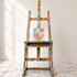 Kerri Rosenthal colorful abstract heart painting on canvas hanging on white wall on easel in art studio