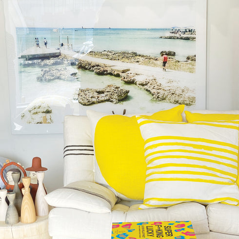 White ground with yellow Stripe on Stripe sunshine decorative throw pillows on couch by Kerri Rosenthal