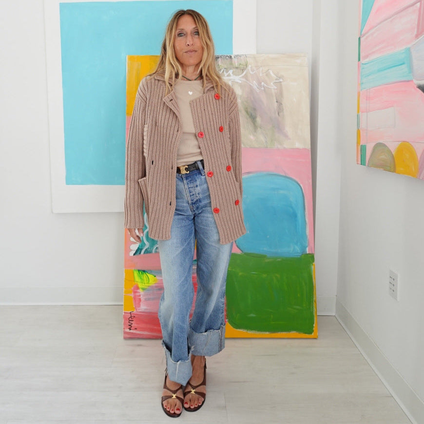 Woman wearing Kerri Rosenthal Brooklyn Girl Sweater Jacket, double-breasted ribbed cardigan with red buttons and patch pockets 