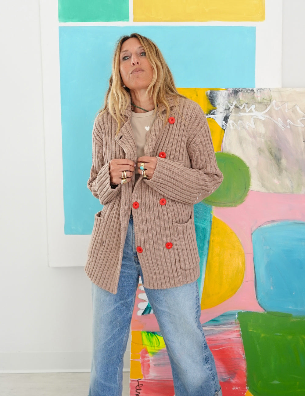 Woman wearing Kerri Rosenthal Brooklyn Girl Sweater Jacket, double-breasted ribbed cardigan with red buttons and patch pockets 