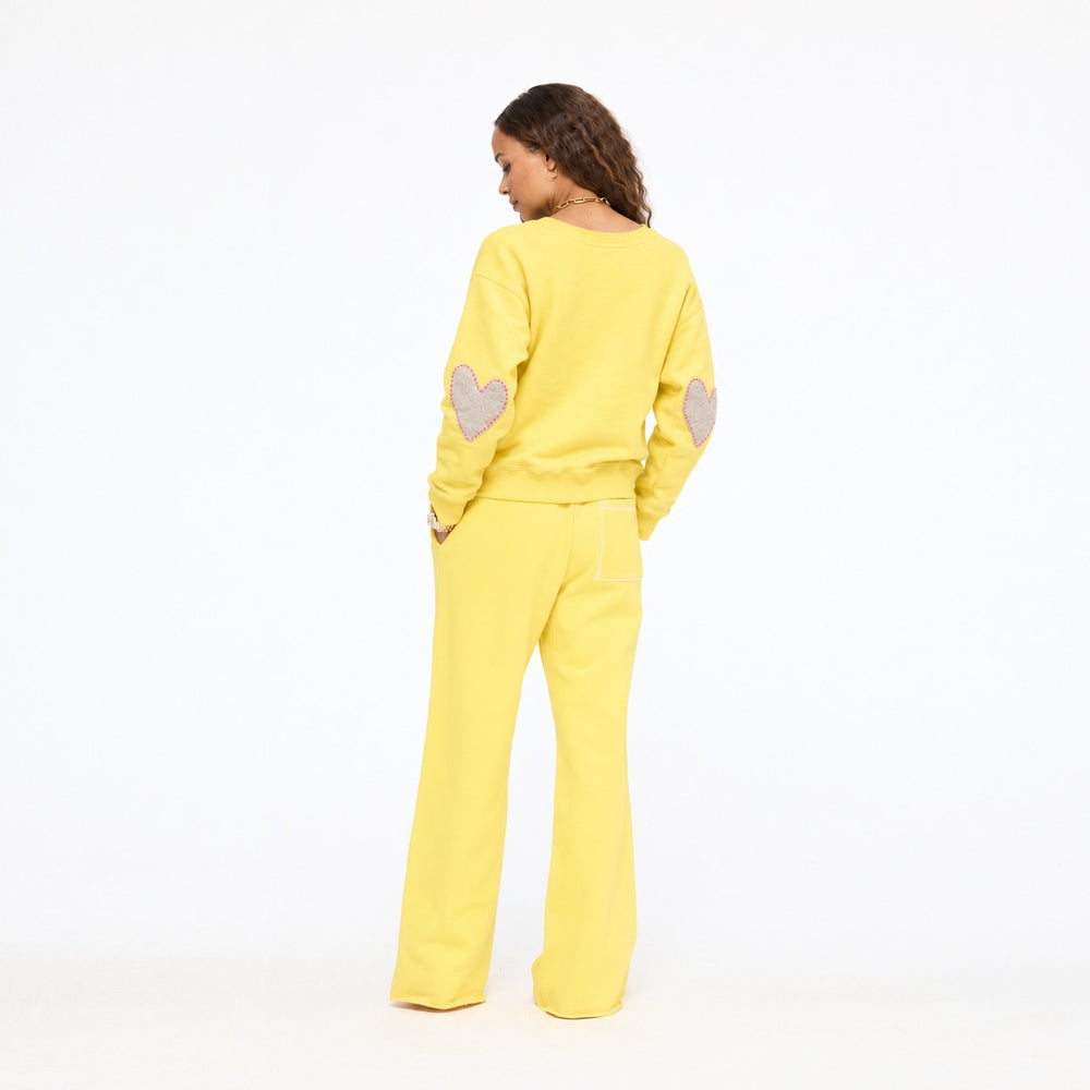 Model wearing the Boyfriend Imperfect Heart Sweatshirt with the Weekend Barb Sweatpant in washed sunshine yellow, back view