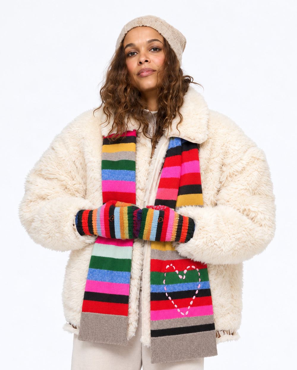 Model wearing the Cloud Nine Jacket in cream with the Fireside Scarf and Kisses Mittens in multicolor stripe and a beanie, front view