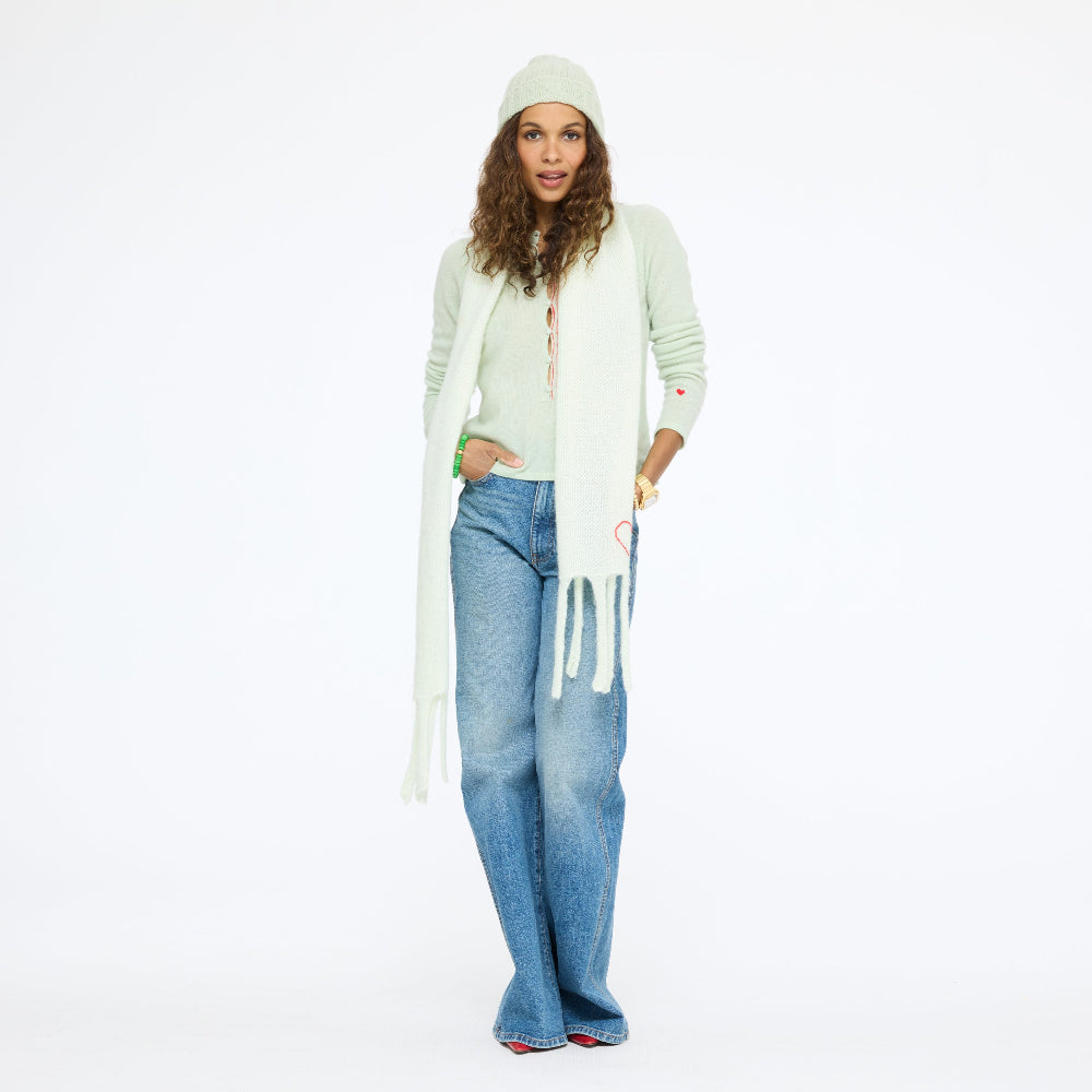 Model wearing the Cloud Hopping Scarf in pistachio with the Winter Beanie and Pixie Sweater in pistachio and wide-leg jeans, front view