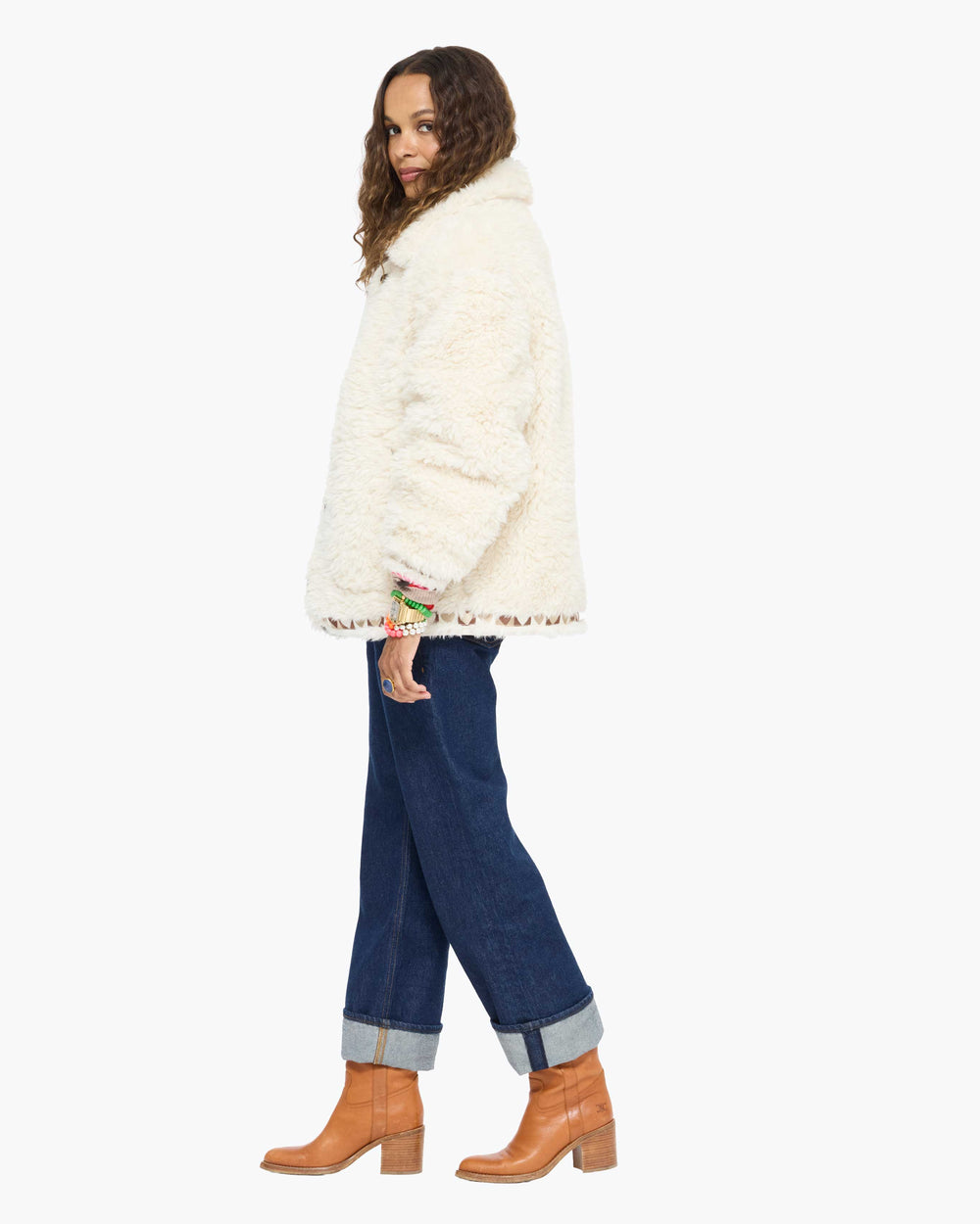 Model wearing the Cloud Nine Jacket in cream sherpa with jeans and tan boots, side view