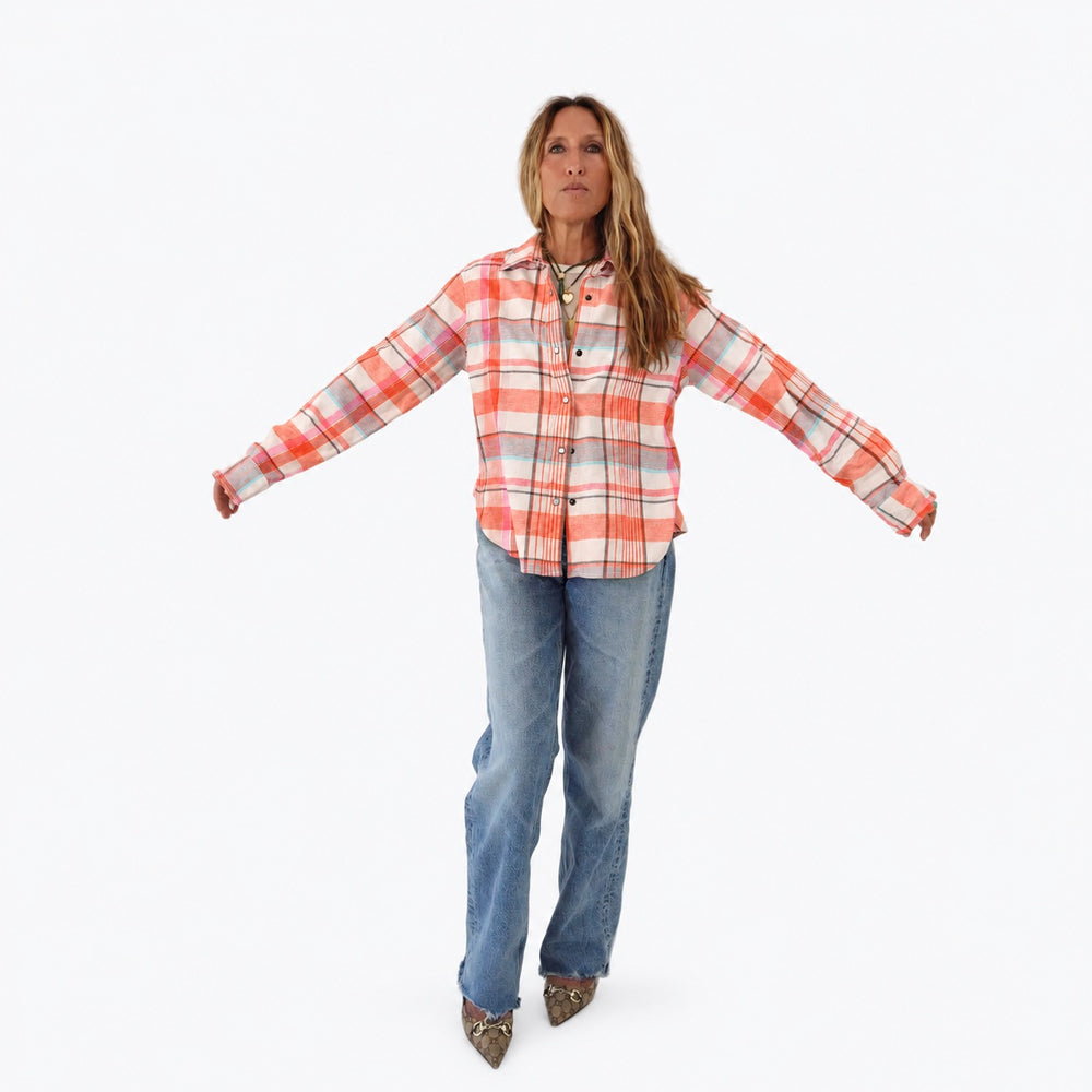 Kerri wearing the Pia Flannel Shirt in coral plaid with jeans, arms held out to the sides