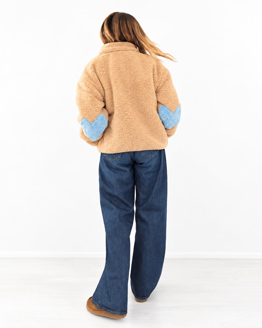 Kerri wearing the Coze Magoze Jacket in Teddy Brown, with light blue elbow patches, styled with dark jeans, side with
