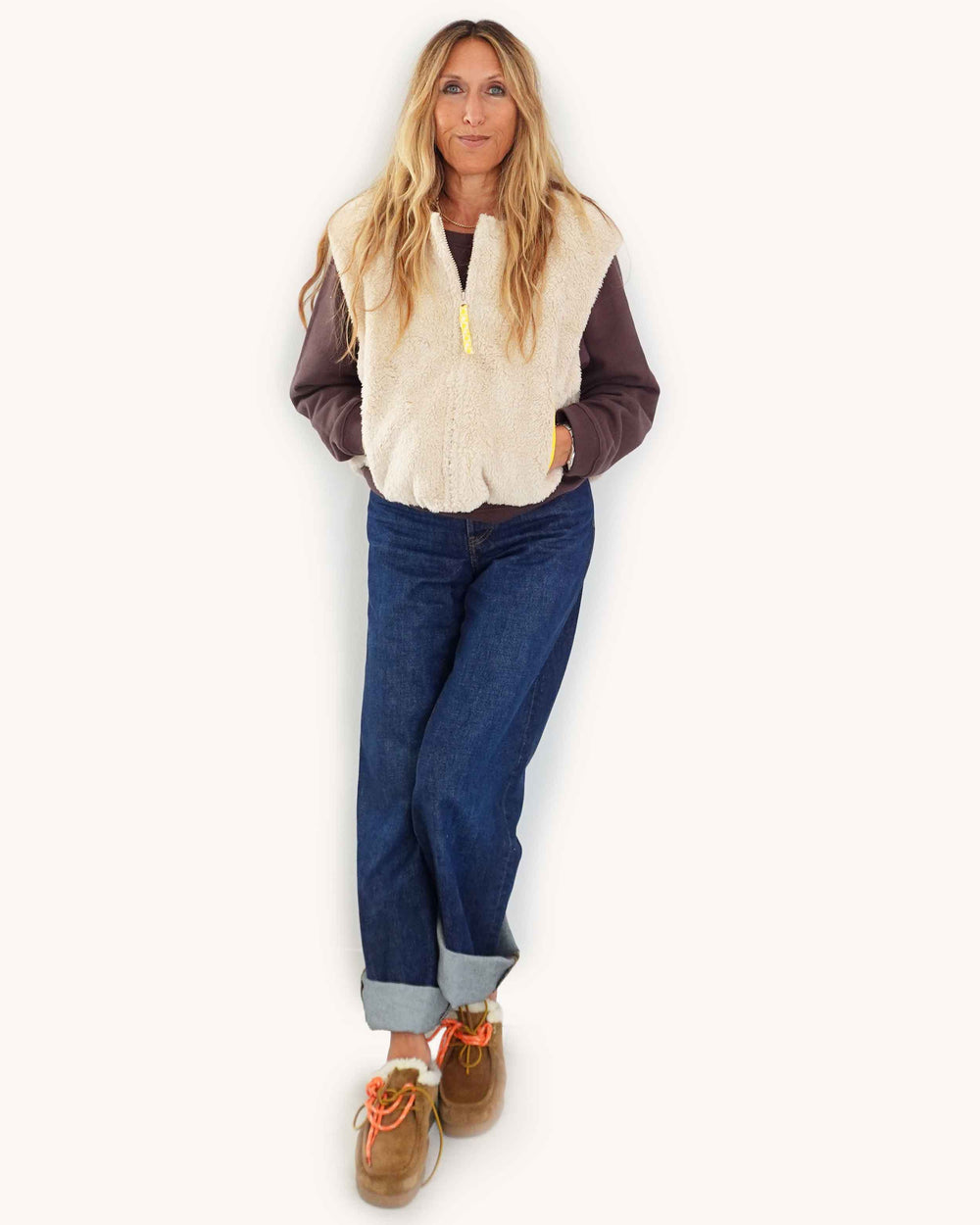 Kerri wearing Coze Vest in cream, with waist band cinched and hands in pockets.