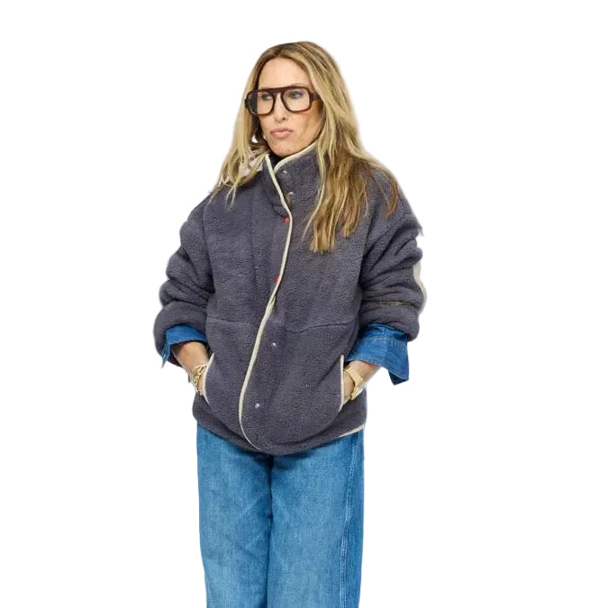 Model wearing gray sherpa jacket with cream contrast trim, snap-button front, and cuffed denim jeans.