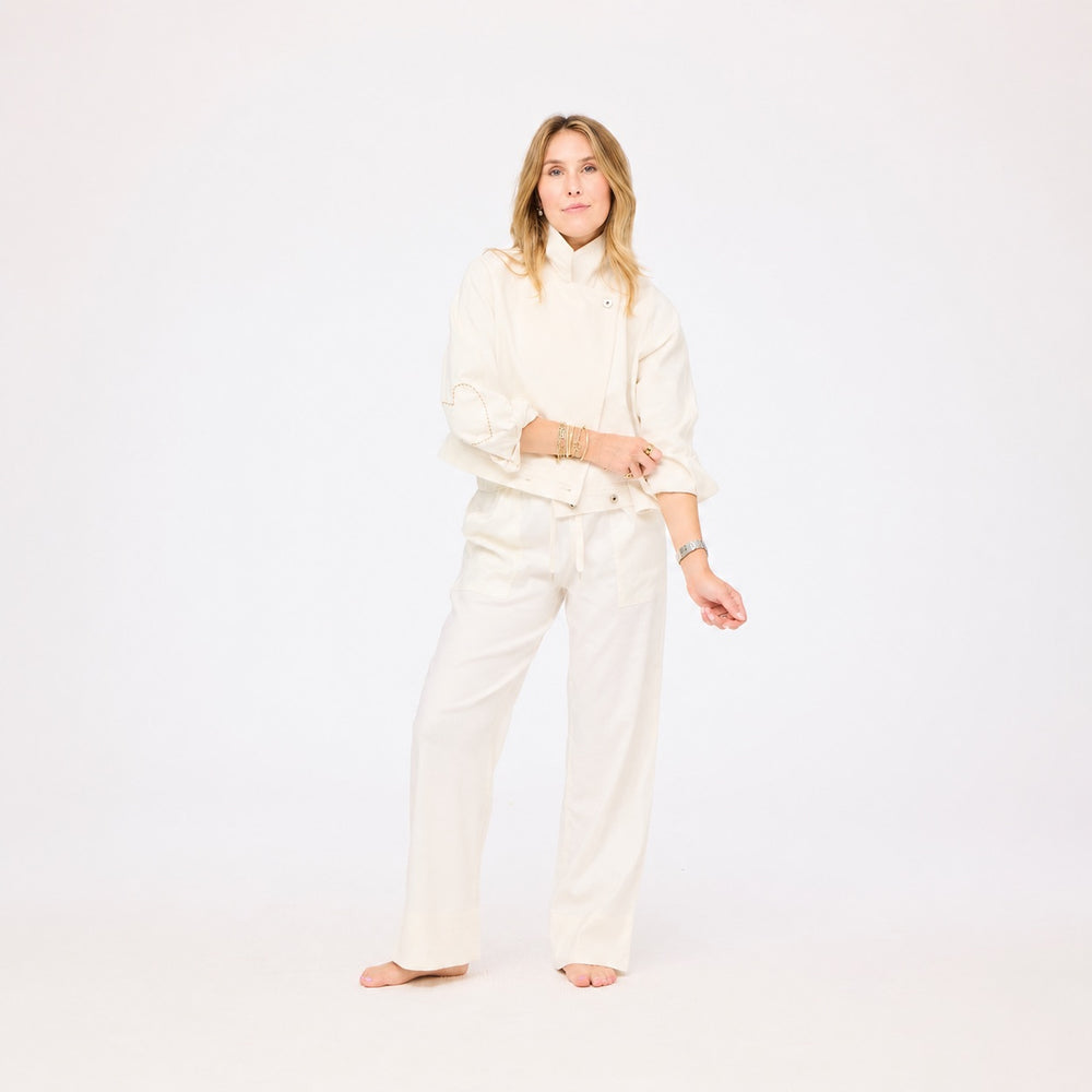 Woman wearing a white outfit on a plain background