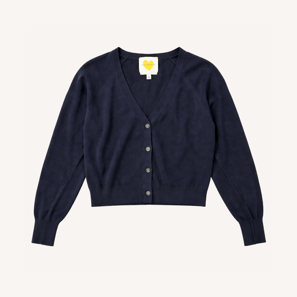Flat lay of a Kerri Rosenthal navy cotton v-neck cardigan with gold heart buttons and yellow heart logo label."