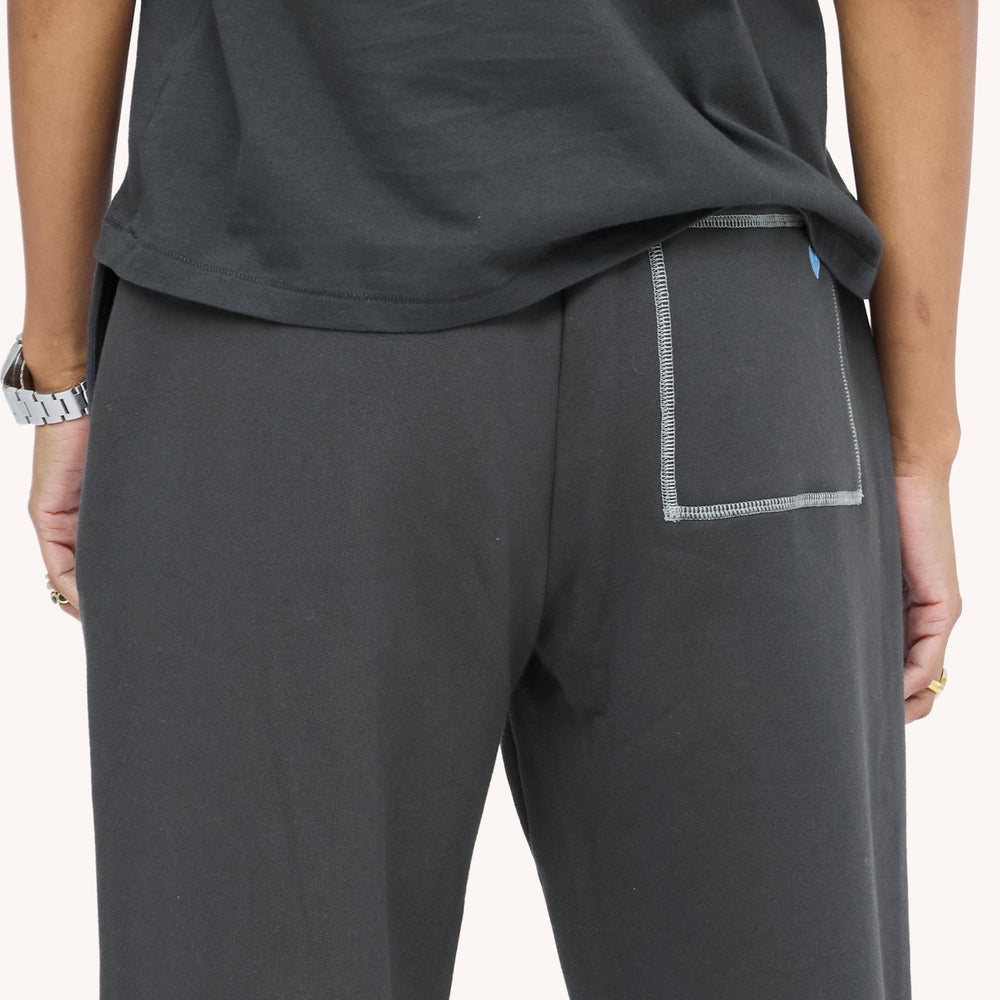 Close-up back view of charcoal sweatpants showing the back pocket stitching detail mini embroidered blue heart.