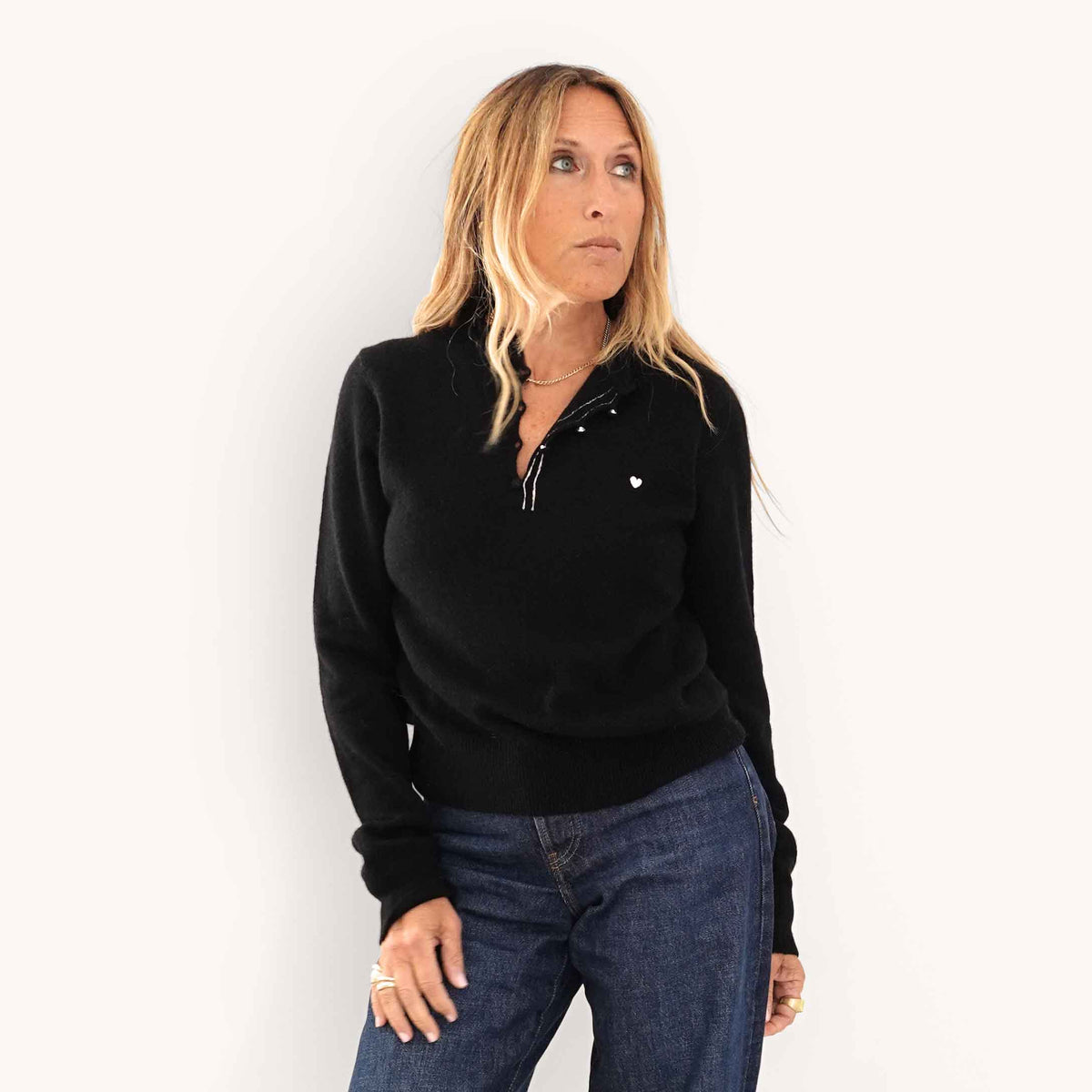 Kerri wearing Femme Ruffle Henley Sweater in Black, styled with dark jeans.