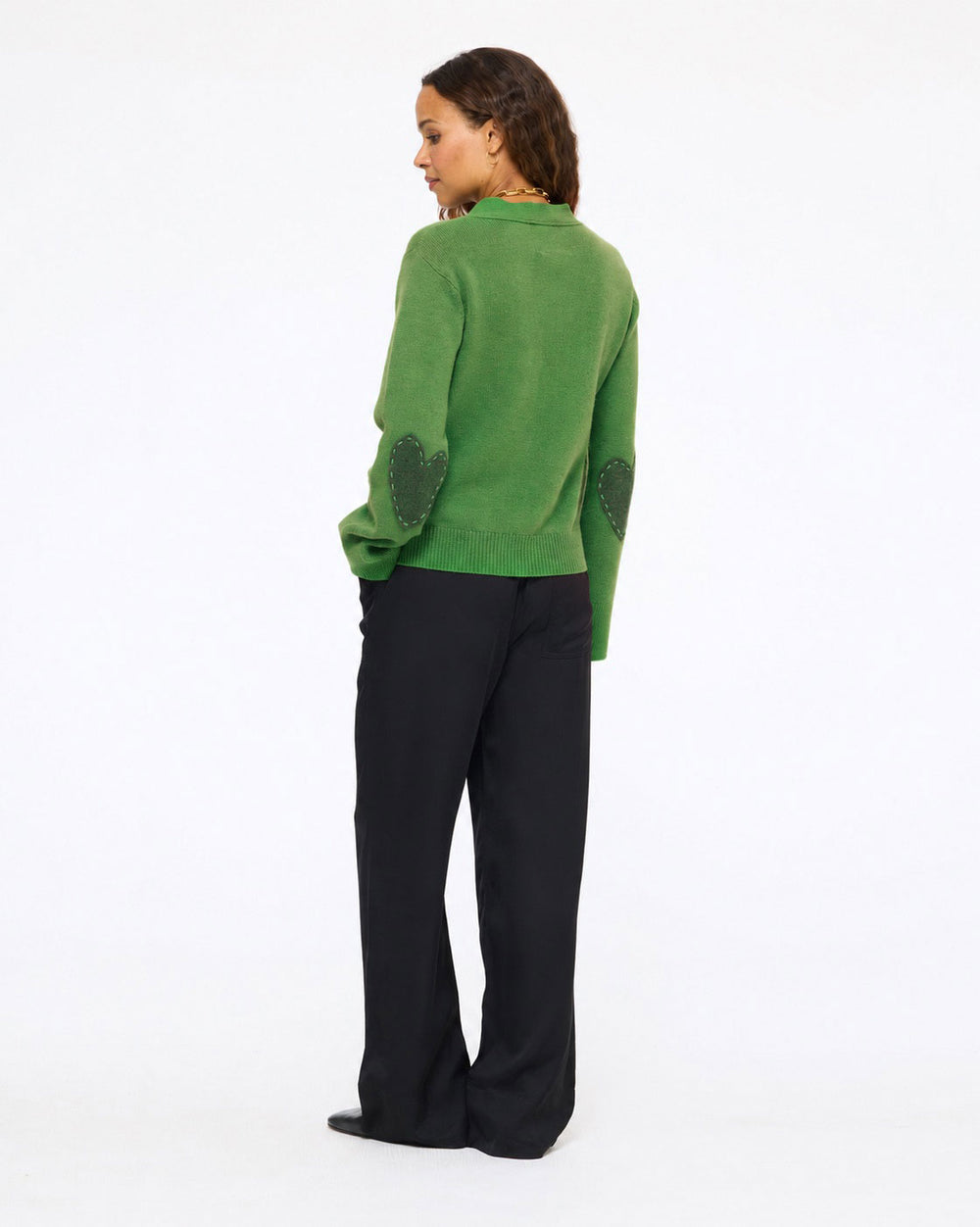 Model wearing the Frances Cardigan in evergreen with black pants, side view