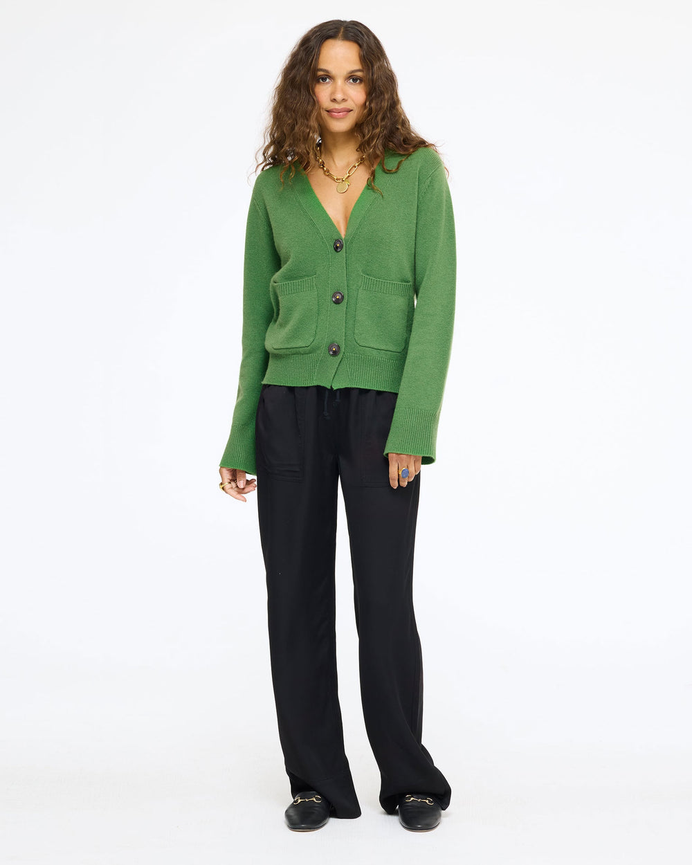 Model wearing the Frances Cardigan in evergreen with the Coast Pant in black and black loafers, full length front view