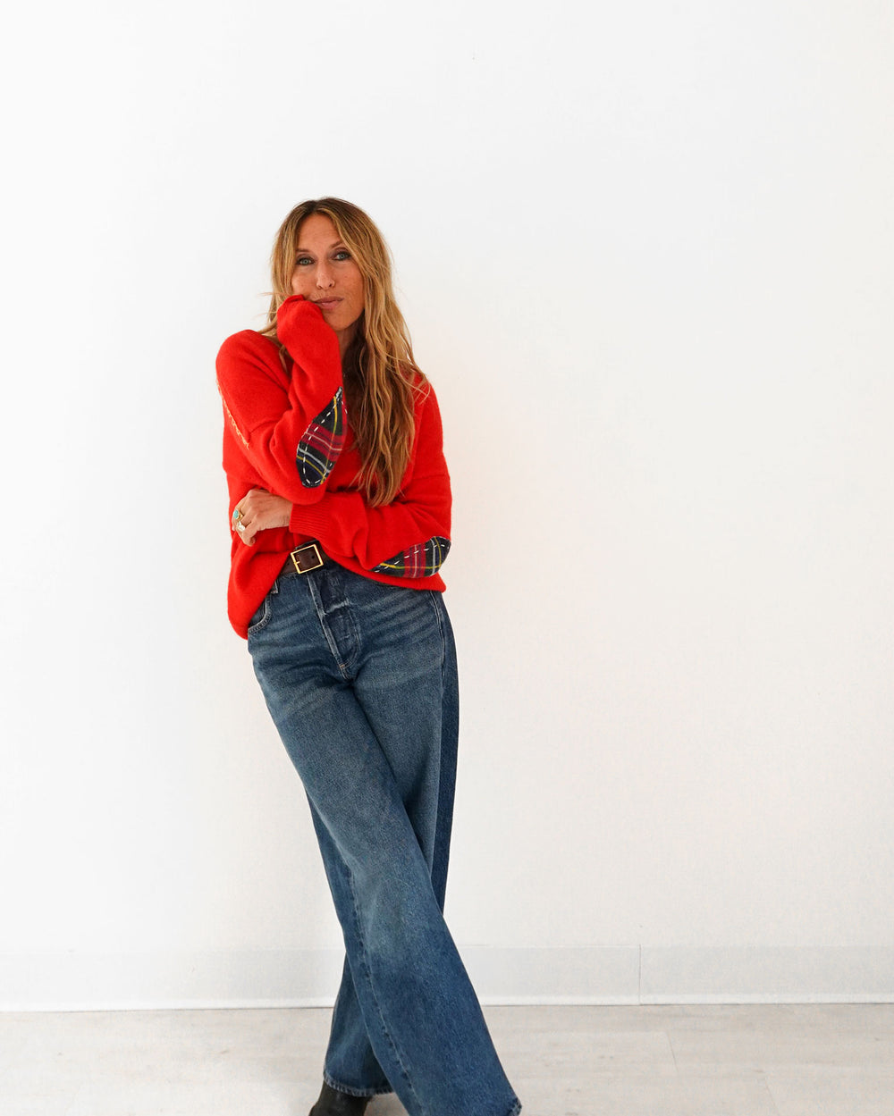 Kerri wearing the Frenchie Patchwork Sweater in red with jeans, three-quarter back view