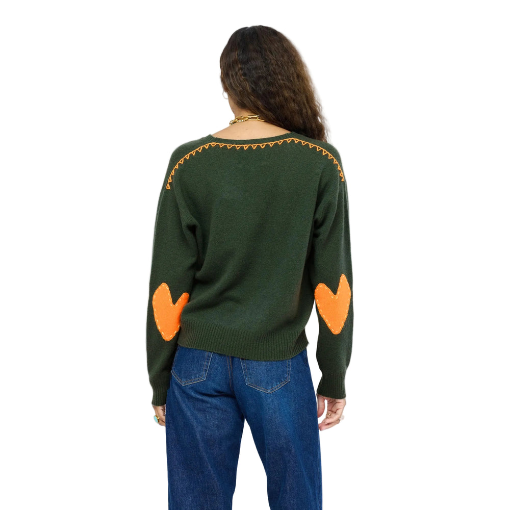 Back view of green cashmere sweater with orange Imperfect Heart elbow patches and hand-stitched zigzag trim along the neckline