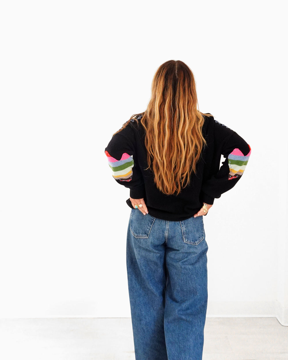 Kerri wearing the Frenchie Patchwork Sweater in black with jeans, back view