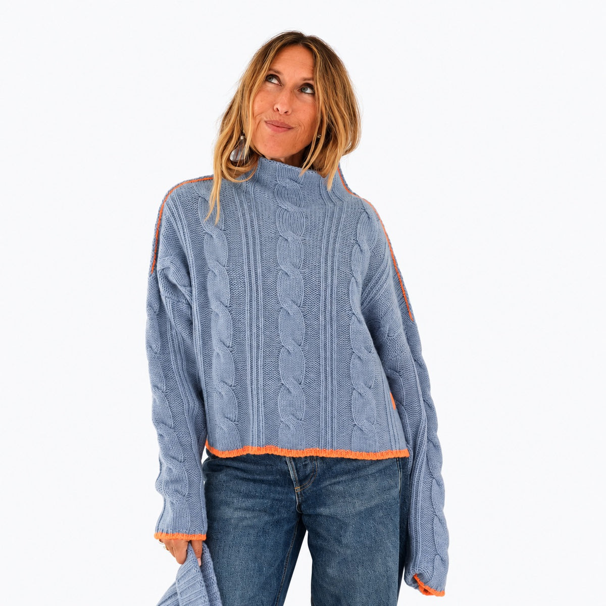 Kerri wearing the Hearth Sweater in blue with orange tipping at the hem, upper body front view