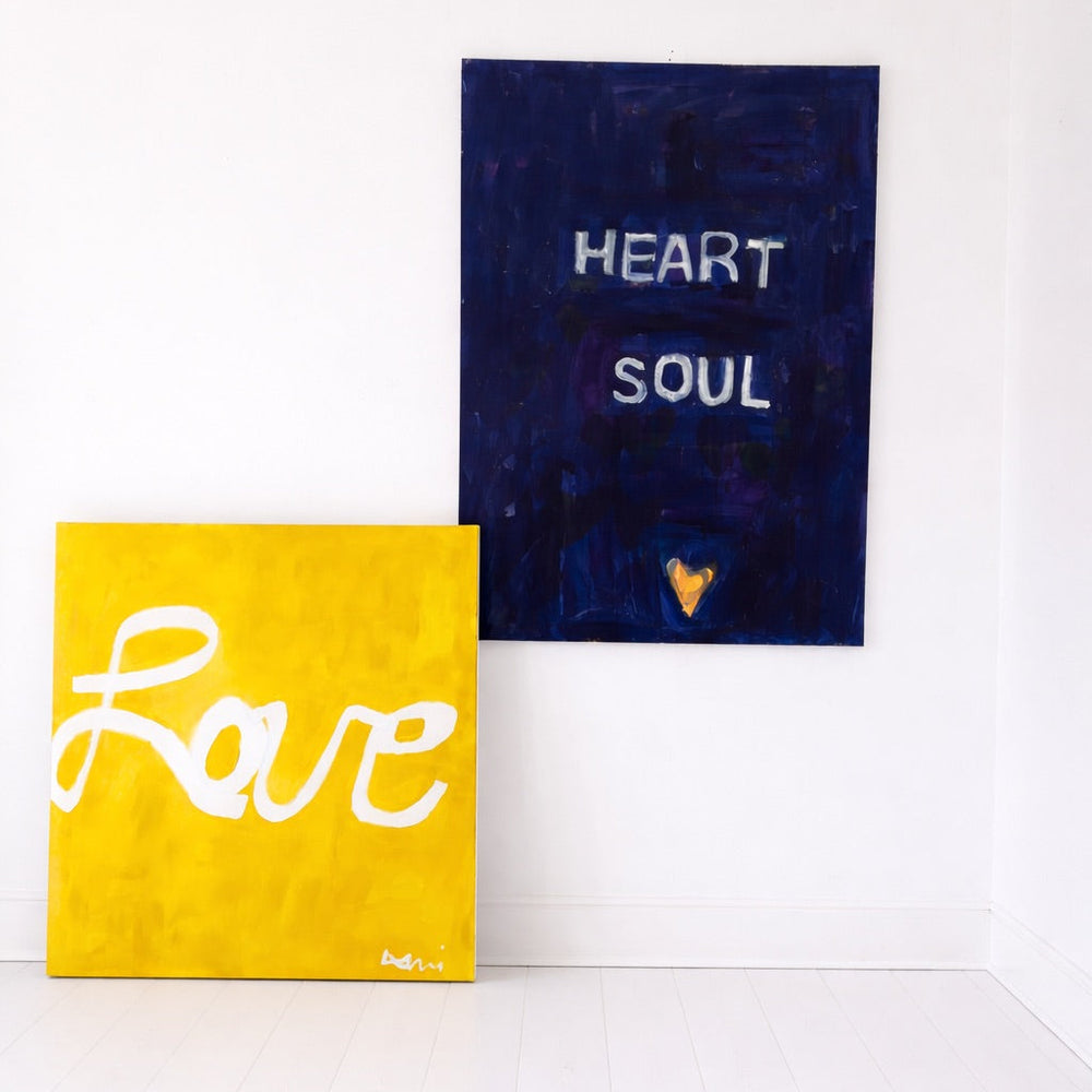 Two wall art pieces on a white background, one yellow with 'Love' and one blue with 'Heart Soul'.