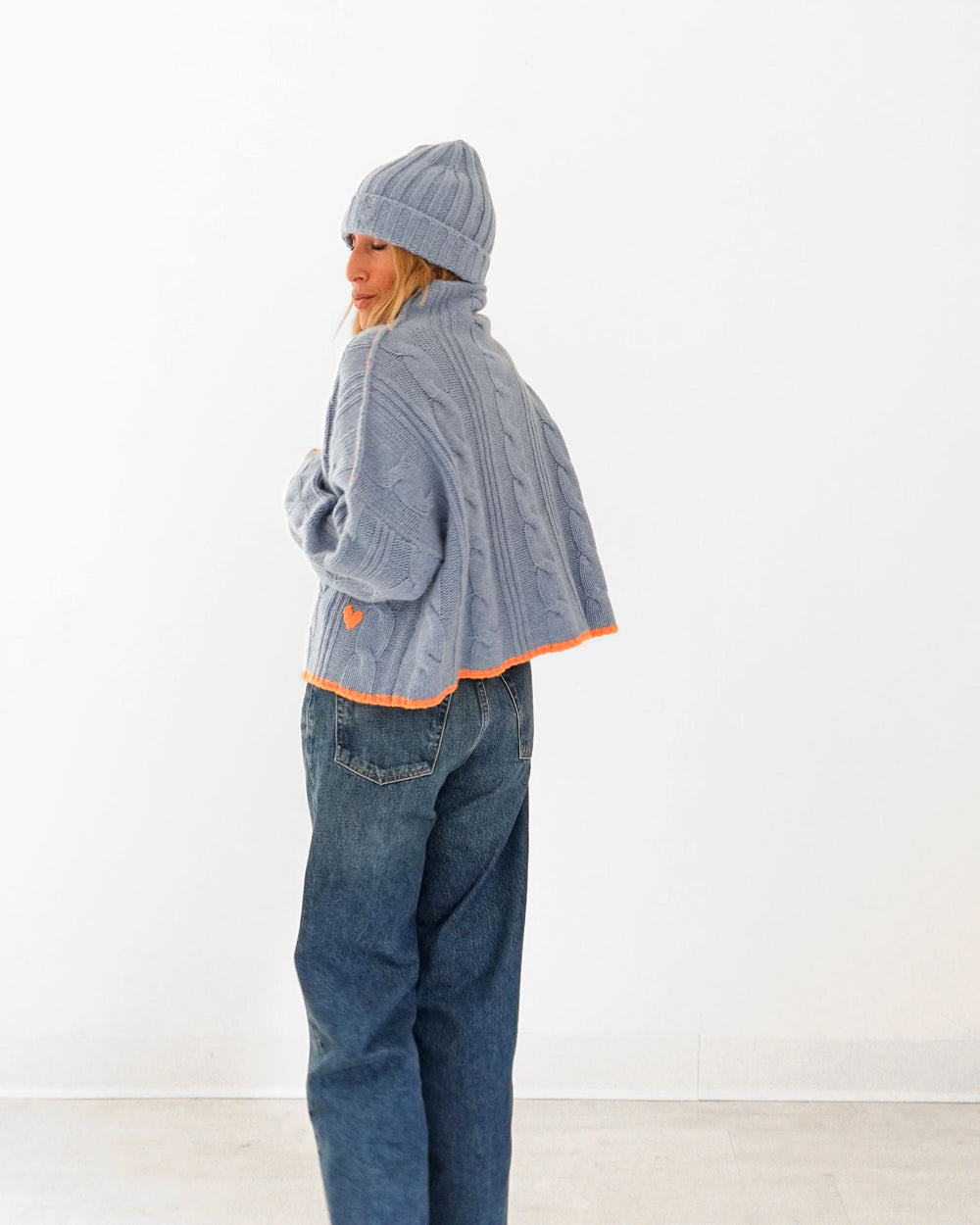 Kerri wearing the Winter Beanie in blue with the Hearth Sweater in blue and jeans, side view