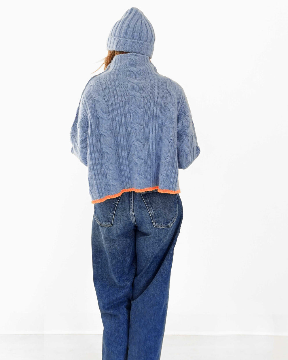 Kerri wearing the Hearth Sweater in blue with the Winter Beanie in blue and jeans, back view