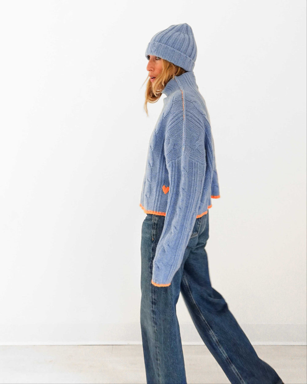 Kerri wearing the Hearth Sweater in blue with the Winter Beanie in blue and jeans, side view