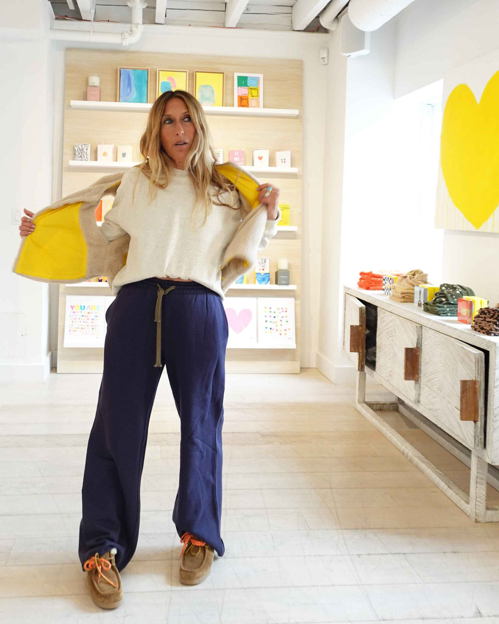 Kerri at the store wearing the Coze vest in cream, flashing yellow lining. Styled with Ex-Boyfriend Sweatshirt in oatmeal heather and with Weekend Barb Sweatpant in indigo blue.
