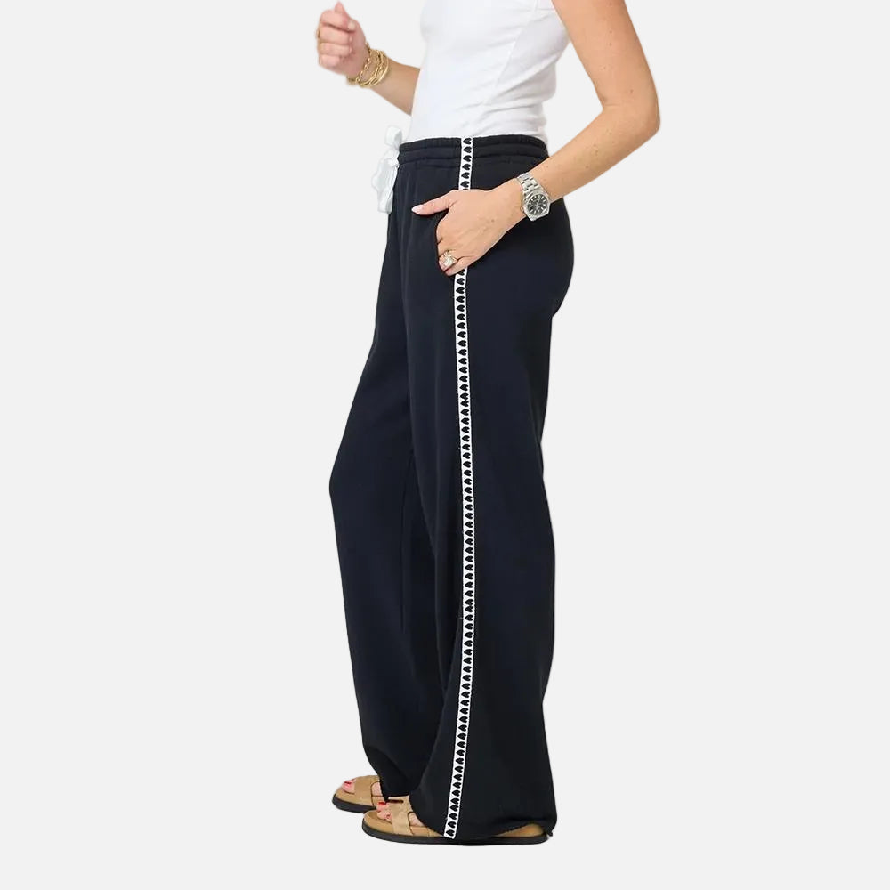 Waist-down side view of the Weekend Barb Heart Tape Sweatpant in black with a heart side stripe and a white tee