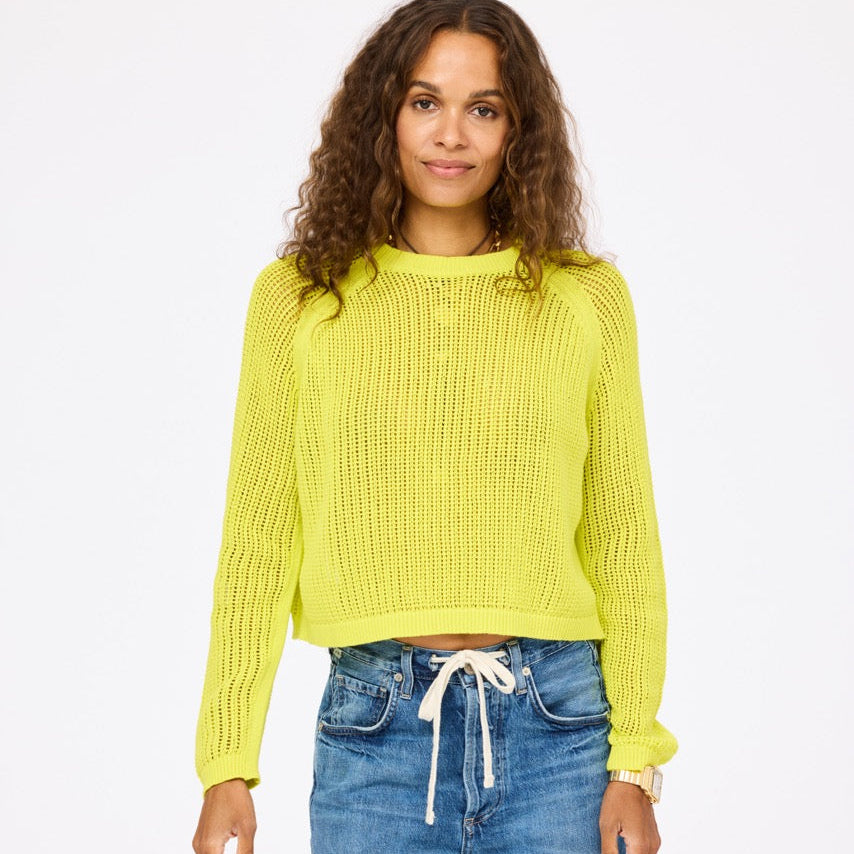 perfect summer open knit sweater in bright citron yellow on a brown haired woman
