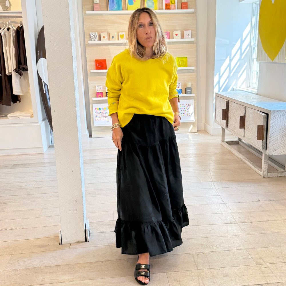 Yellow sweatshirt layered over grey with black maxi skirt, everyday casual style