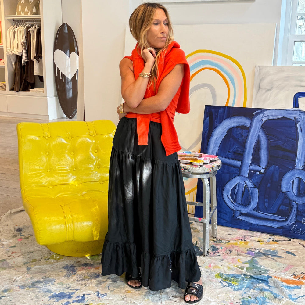 Women's orange knit top with black ruffled maxi skirt, boutique lifestyle shot