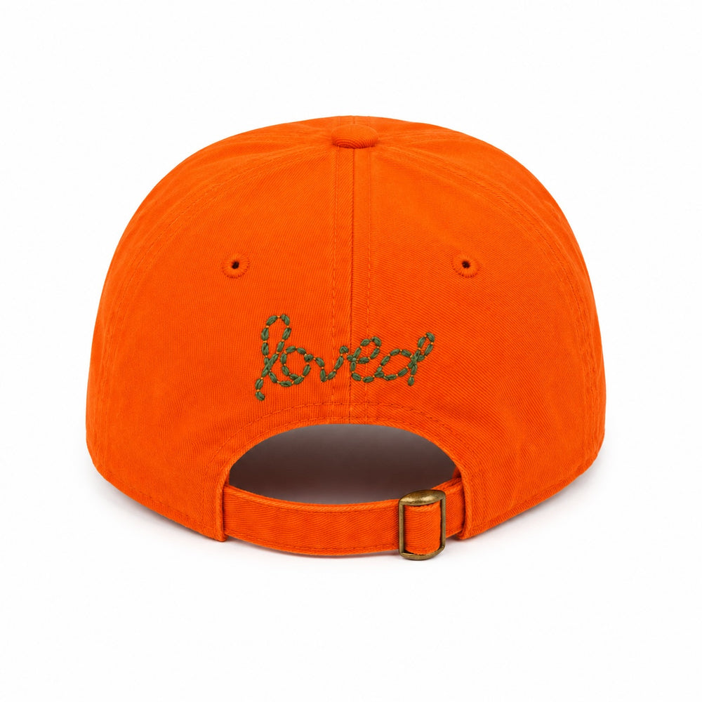 Kerri Rosenthal Imperfect Heart baseball cap in orange with loved stitched in green on back.