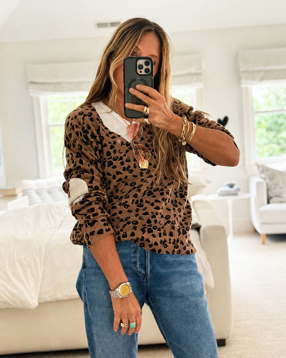 Leopard print knit sweater in camel and black, V-neck with ribbed hem, worn over a white shirt and straight-leg denim
