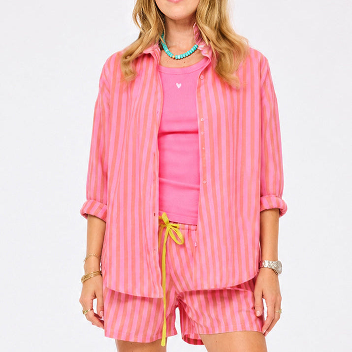 Women's pink and orange striped oversized button-down shirt and shorts co-ord set, styled with a hot pink tank top. Shop Kerri Rosenthal tank tops