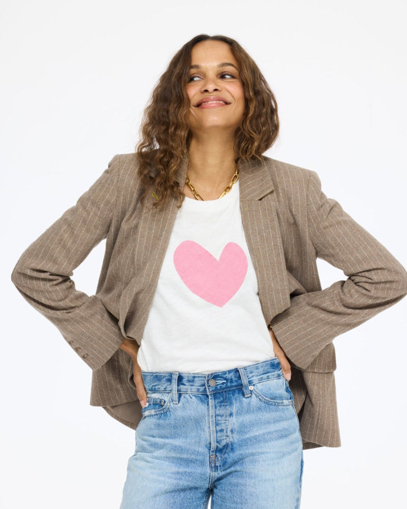 Model wearing the Long Sleeve Suke Imperfect Heart Tee in cream with a pink heart under the Workday Love Brigade Blazer in taupe and jeans, front view