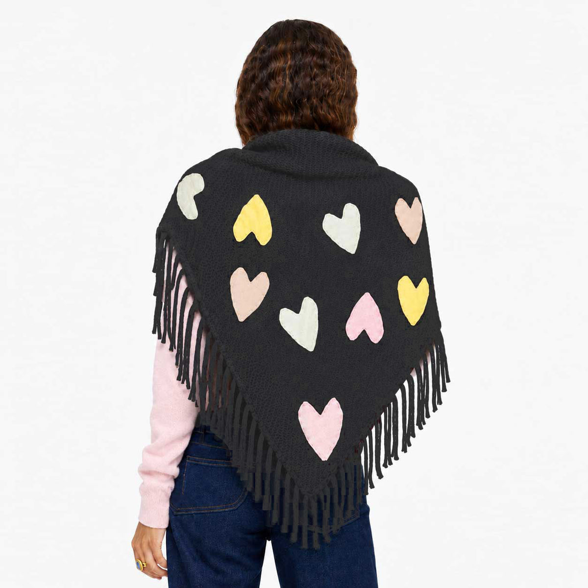 Person wearing the Love Nest Zero Waste Wrap in black with patchwork hearts and fringe edges