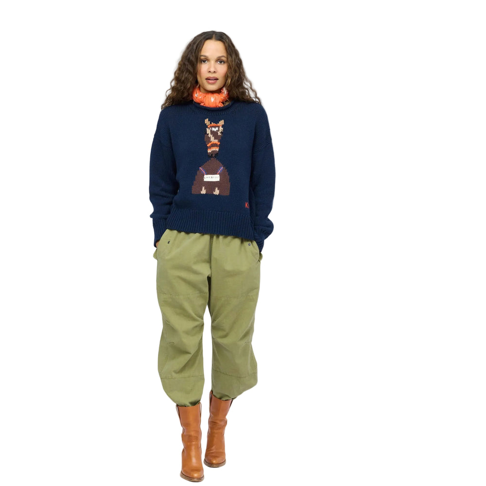 Kerri Rosenthal indigo Love Reigns sweater and olive pants, full-length front view with brown boots