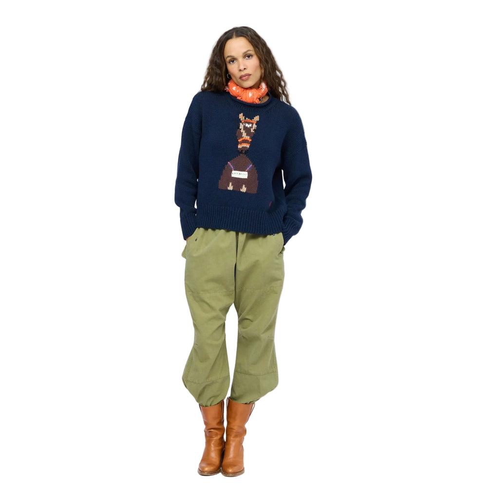 Kerri Rosenthal indigo Love Reigns sweater and olive pants, full-length front view with orange scarf