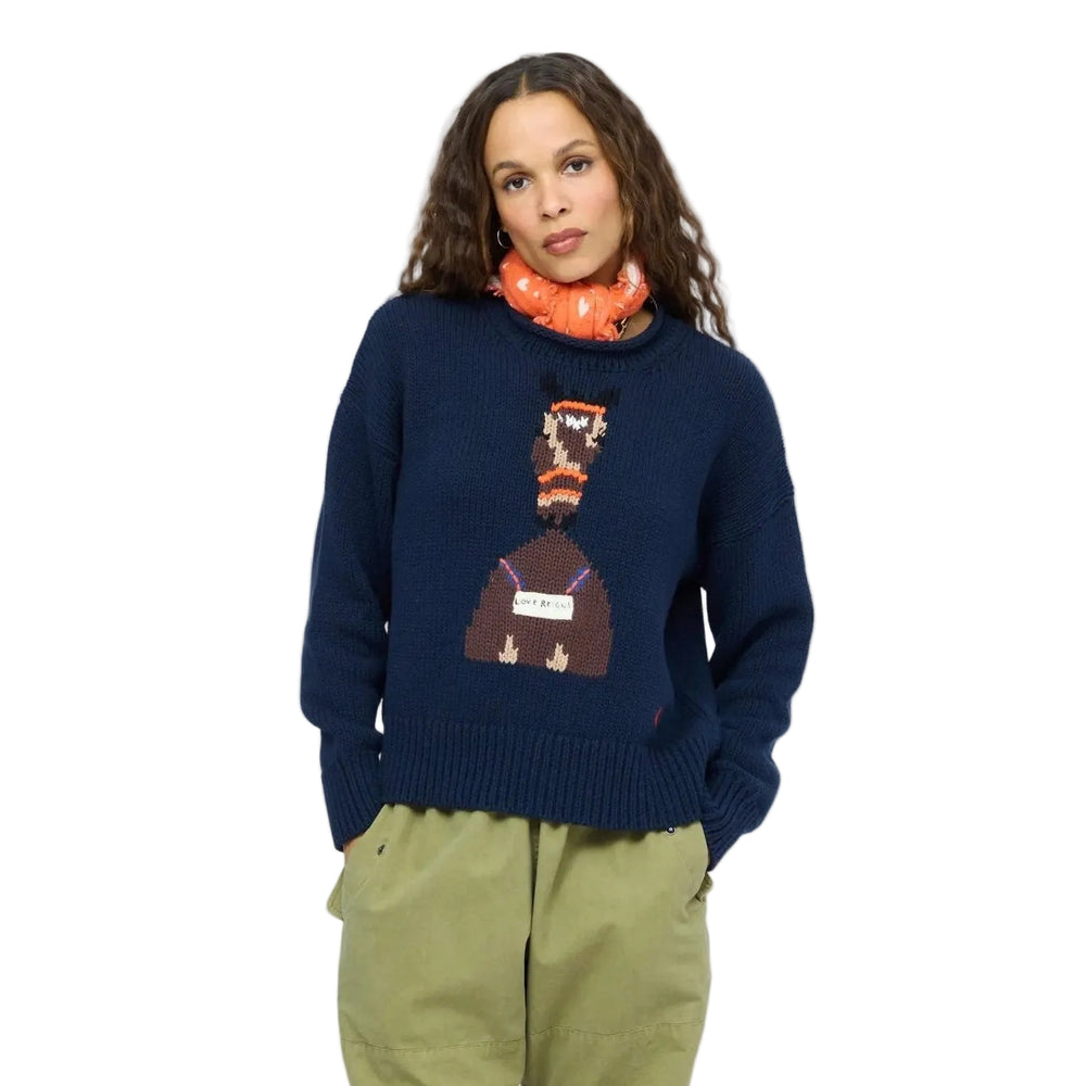 Kerri Rosenthal orange heart-print bandana worn as a neck scarf, styled with a navy graphic sweater and khaki pants