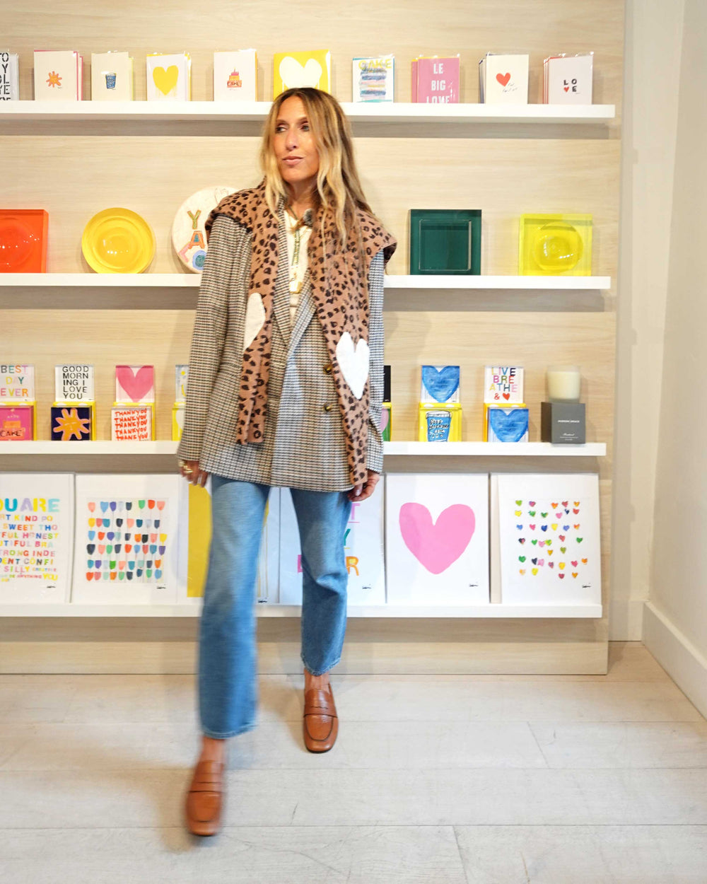 Kerri wearing the Mr. Frenchie Blazer with heart patches and the Frenchie Featherweight Cashmere Nomad Sweater tied around her shoulders, styled with jeans.