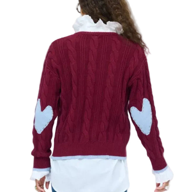 Kerri Rosenthal Maxwork Cable Pullover Sweater in Burgundy, back view showing cable knit texture and patchwork elbow detail, layered over a white shirt with jeans.