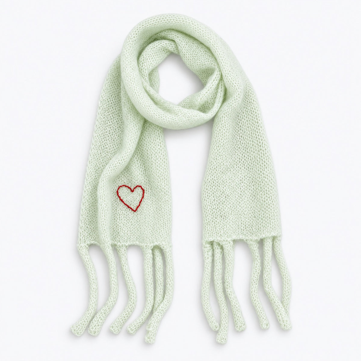 Flat view of the Cloud Hopping Scarf in pistachio with fringe ends and a red embroidered heart