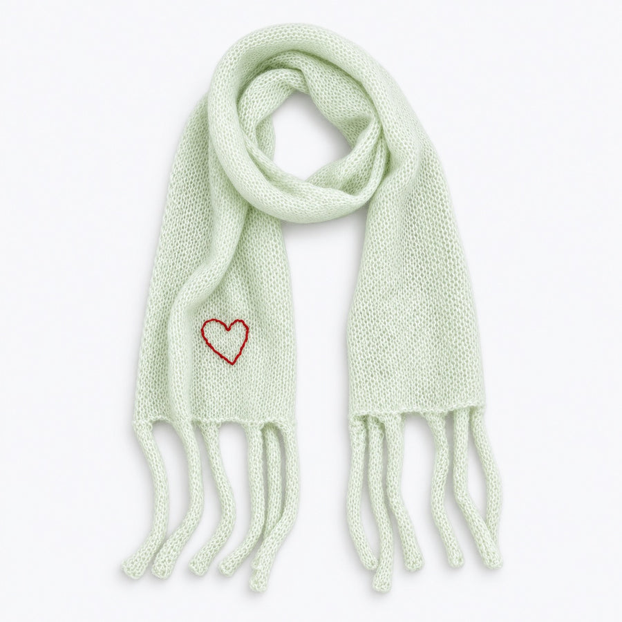 Flat view of the Cloud Hopping Scarf in pistachio with fringe ends and a red embroidered heart