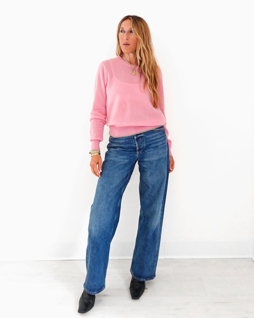 Kerri wearing the Patchwork Pullover Sweater in pink with wide-leg jeans, full length front view